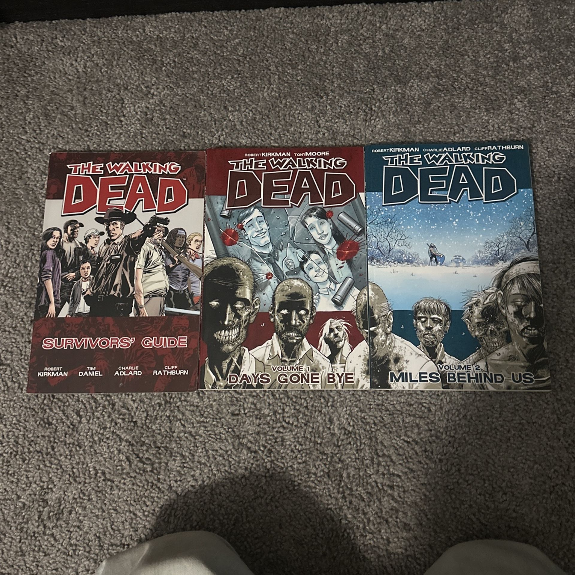 THE WALKIN DEAD COMICS, volumes 1 and 2, and the survivors guide.