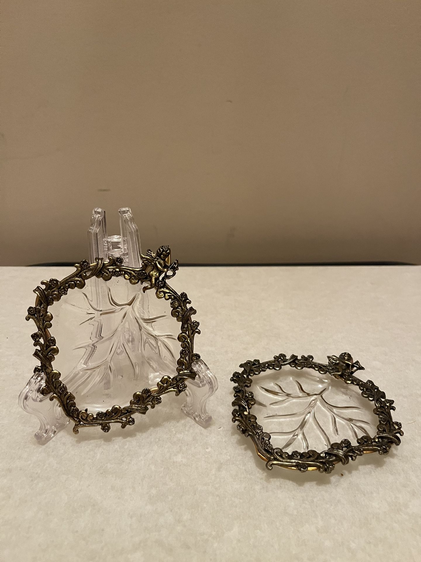 2 beautiful vintage vanity dishes. Intricate design. Leaf shape. Cupid siting on top. Collection pieces. Really nice for your jewelry, etc. in good co