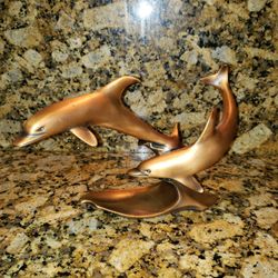 Gold Statue Of Two Dolphins Swimming 