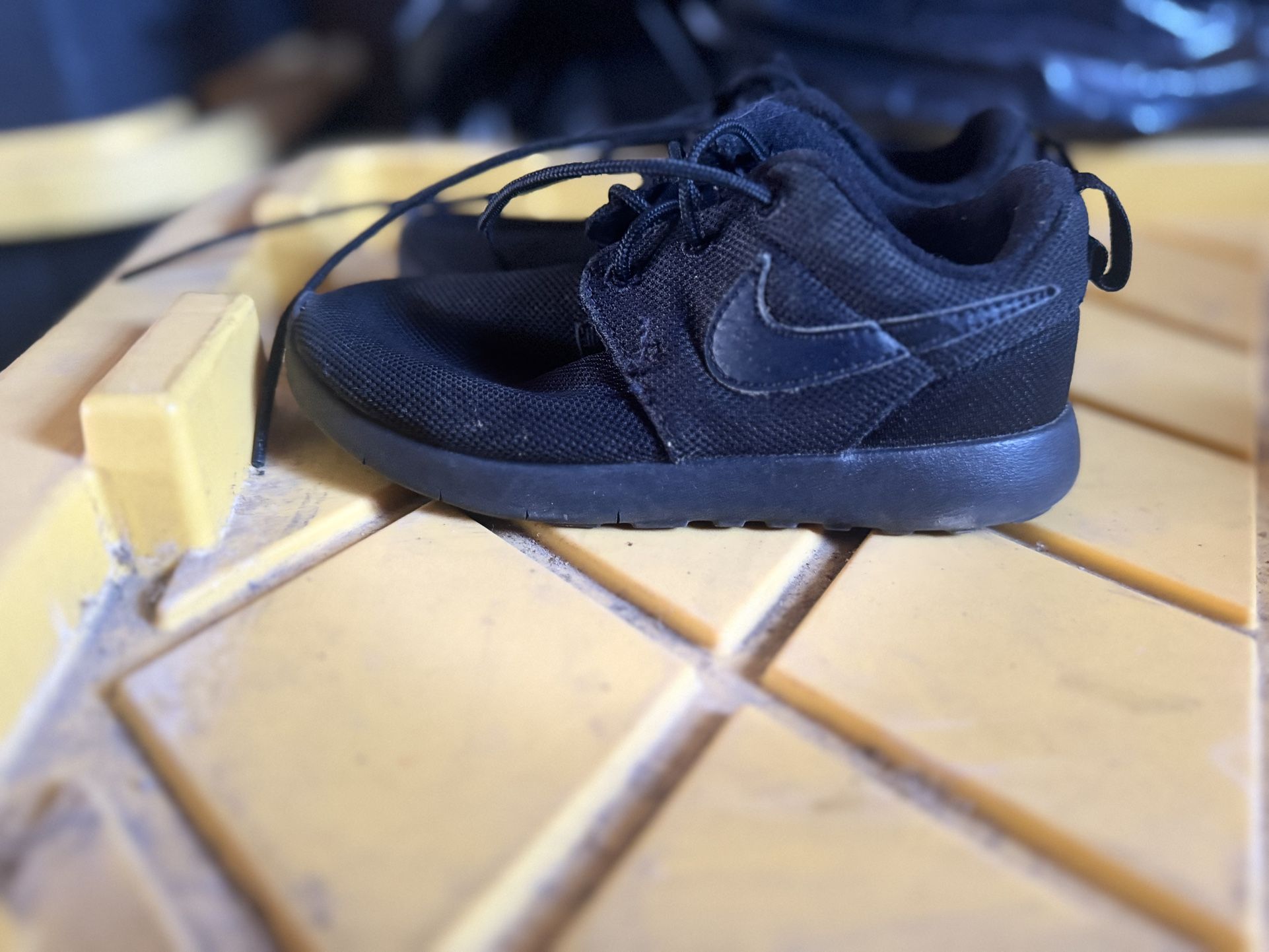 Nike Roshe One sneakers in a "triple black" In kids size 11c