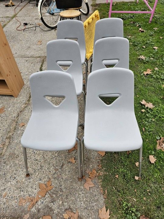 6 Plastic Chairs. Grey In Color. 
