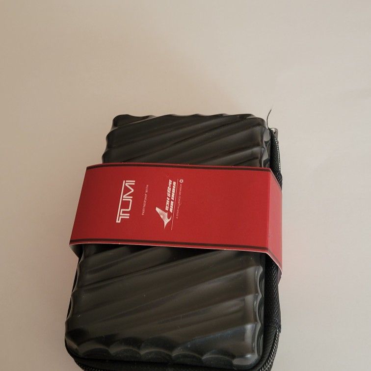 Tumi Air India The Mini Suitcase Toiletry Case Amenity Kit Pouch Zipped 
New. Like New.  Great for travel. Include toothpaste and toothbrush, 
hand cr