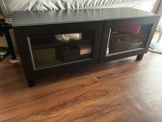 Medium sized black entertainment center. With glass doors.