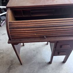 antique or vintage child's roll-top desk, likely made of oak. 