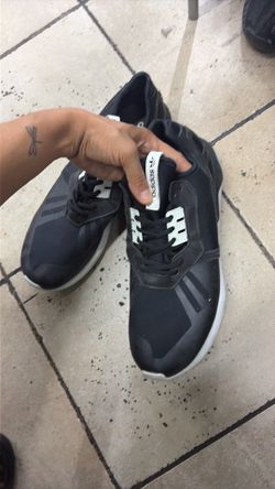 black Adidas Originals Tubular Runner sneakers feature white detailing on the lace cages and tongue branding.