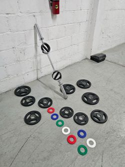 Versatile weightlifting set includes a chrome-finished barbell with dual rotating knurled handles.   The set has ten black rubber-coated grip plates i