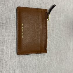 Michael Kors Jet Set Travel small Saffiano leather top zip coin pouch with an ID window in the color brown/acorn. 