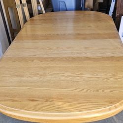 Solid oak table with two chairs. 
