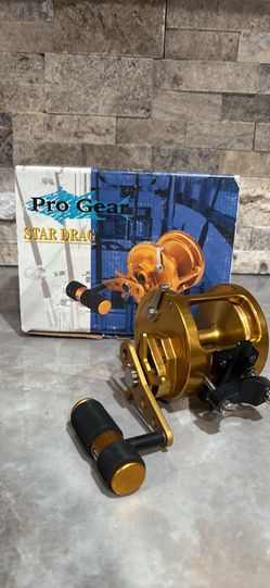 PRO GEAR PG 400 Star Drag Reel -NEW IN BOX-Gold fishing reel. Has black handle with gold accents. Comes with original box. Reel is marked PRO GEAR 440