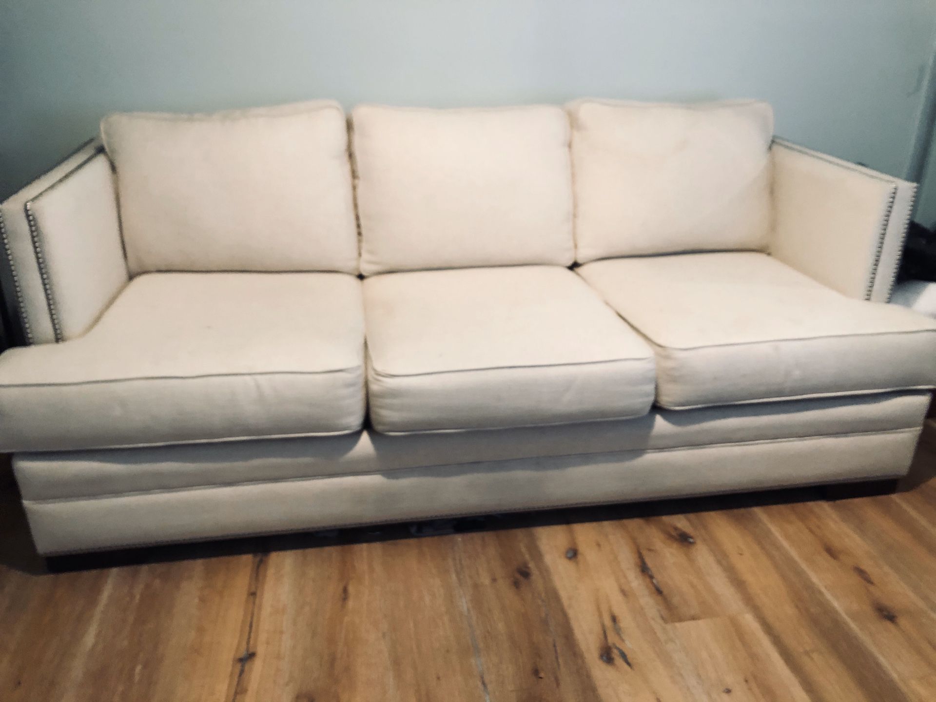 Cream linen couch with nailhead trim