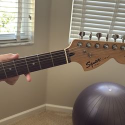 Fender electric guitar  and Squier Strat Fender and speaker/amplifier and a bag with accessories.