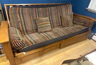 Futon with a wooden frame that converts to  a full size bed. Multi colored mattress