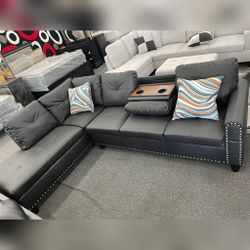 Black faux leather sectional sofa with drop down table 
