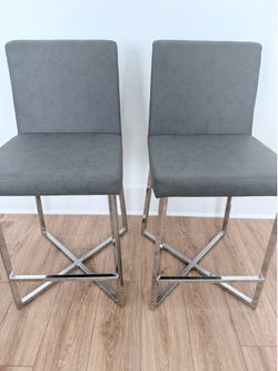 A pair of Pasha 24” Leather Stools