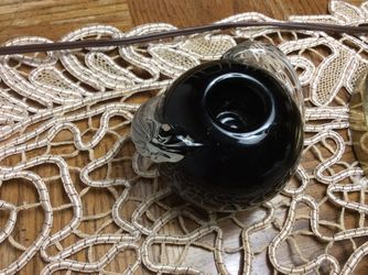 A Black Glass Candel Holder serawended with a snak for $2