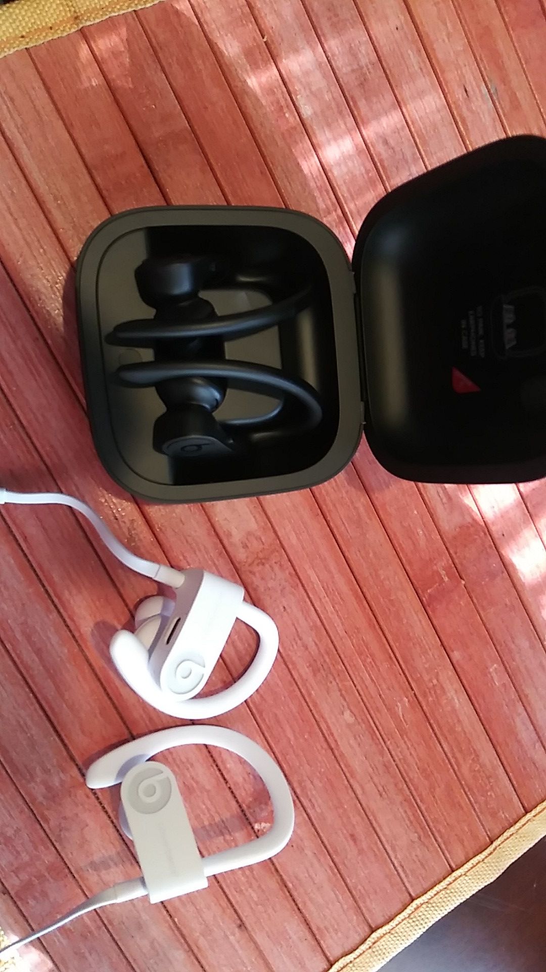 Black wireless BEATS ear buds with charging case..White BEATS EARBUDS