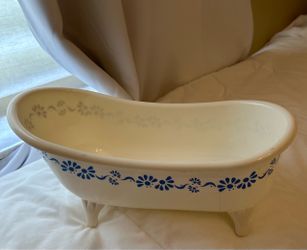 White plastic bathtub for dolls with a blue floral garland design along the exterior.  Bath Tub For Dolls Plastic 15 x 7”