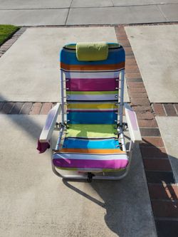 Lightweight beach lounge chairs with a blue, green, and white striped pattern. Each chair has a foldable metal frame for back support and an attached 