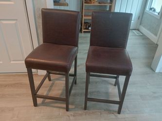 4 counter height chairs/stools. Wood frame, brown bonded leather seats.