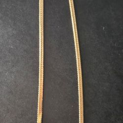 gold-tone herringbone chain necklace with a lobster clasp. 