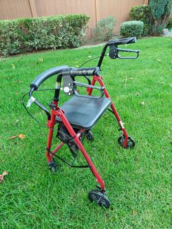 4 Wheel Drive Medical rollator walker features a red steel frame and a padded