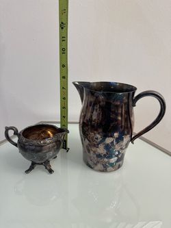 Vintage but beat up silver plated creamer, and Paul Revere reproduction water pitcher