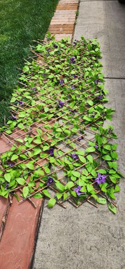 Artificial expandable privacy fance, with purple flowers.