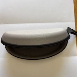 This is a hard-shell zipper eyeglass case. • Design: The surface is made of grey fabric, with a semi-elliptical shape, suitable for storing reading gl