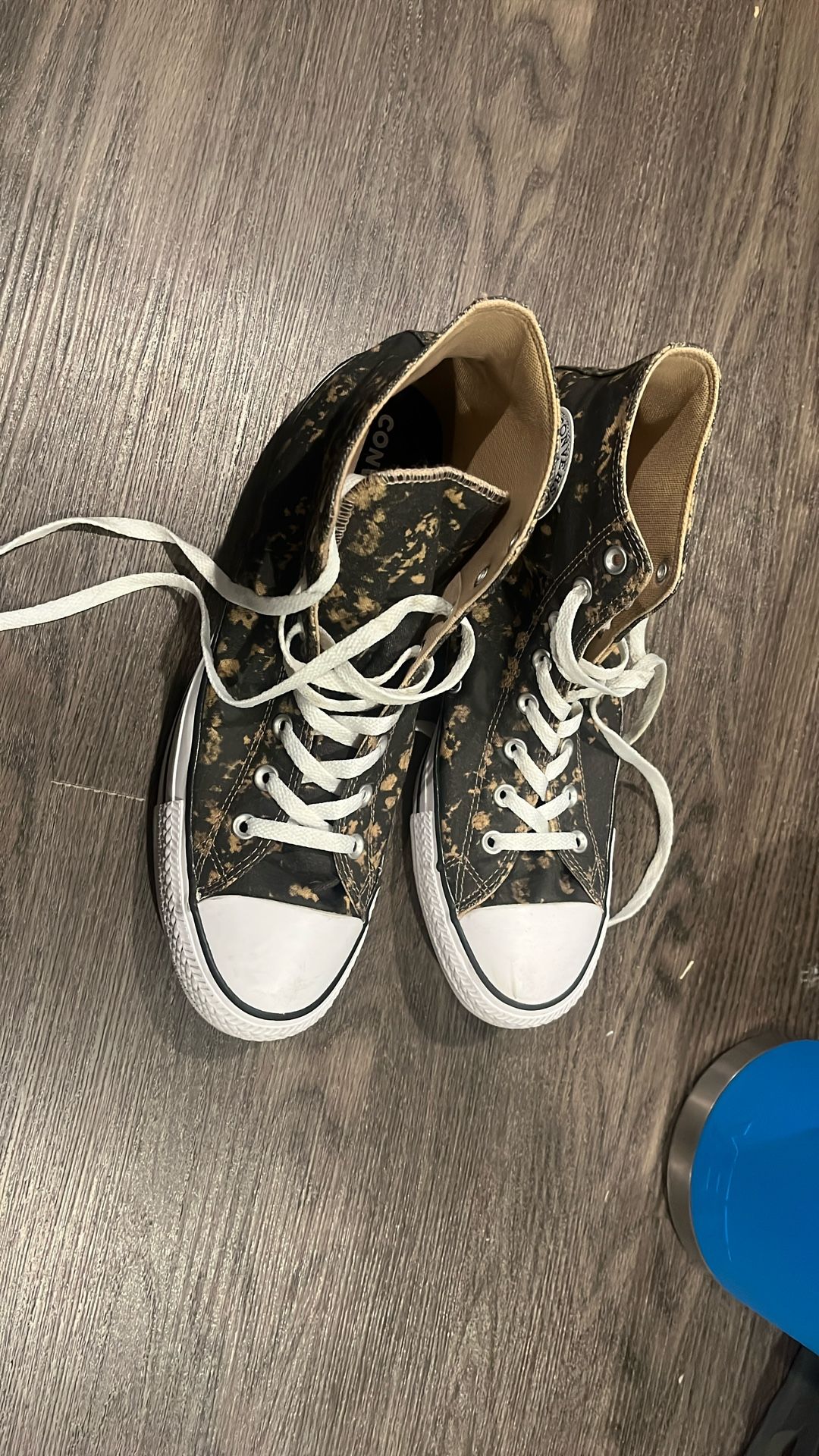 high-top Converse ( Chuck Taylor / Chuck 70 / All Star style with a black canvas Base And A bleach-splatter effect.