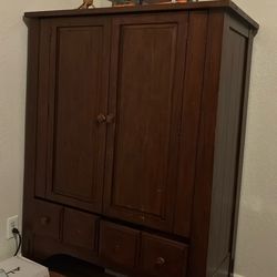 dark wood armoire or wardrobe with a traditional or potentially Mission-style design