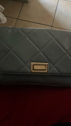 This item is a white quilted flap handbag featuring a distinctive gold-tone rectangular twist-lock clasp and a woven gold chain and faux-leather shoul