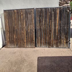 Black metal door gate. Wood panel.  Size. 10' feet wide X. 6' feet tall.    $.  290.