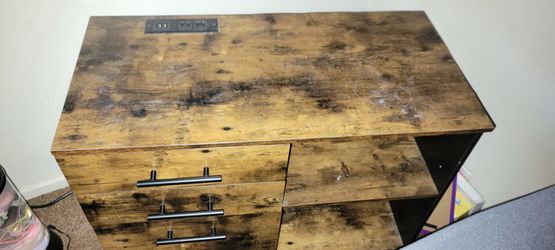 Office dresser with charger ports and plugs.