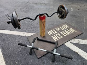 120 Pounds aprox. Black EZ curl bar with visible rust and wear, loaded with cast iron weight plates. Four additional tri-grip plates included. Heavy u