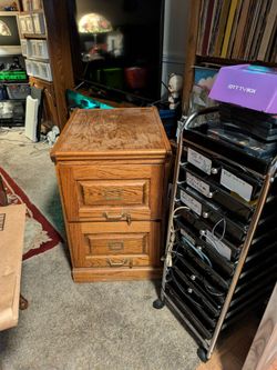 Solid oak 2 drawer filing cabinet has brass fittings on it