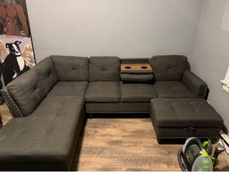 Grey sectional with ottoman and cup holders