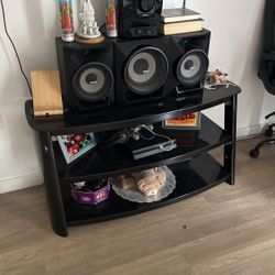 Glass table with the speaker and the TV. 