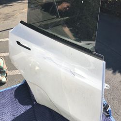 2022 TESLA MODEL Y rear Passenger right door in pearl white color  Used Has rip/ tear  on the side  Comes with glass and door panel 