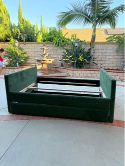 Mdern upholstered velvet platform bed with a hidden footboard storage drawer in dark/emerald green.