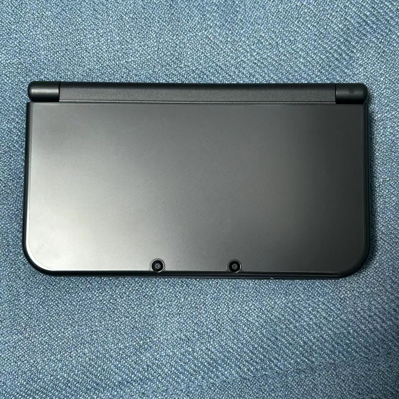 A collector-grade original Japanese black New 3DS XL. The exterior is nearly flawless, with only minor light-reflective marks. Both screens are very w