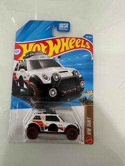 New Hot Wheels Lil' Roar die-cast car from the HW Dirt series. This white off-road vehicle has orange and black graphics with brown wheels. It is part