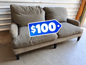 Gray upholstered nail head feather filled loveseat