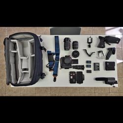 Canon T7I DSLR camera with multiple lenses and gear.