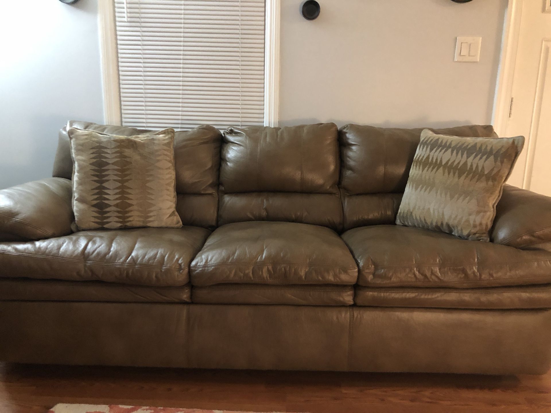 One year old brown leather couch , oversized chair , with ottoman