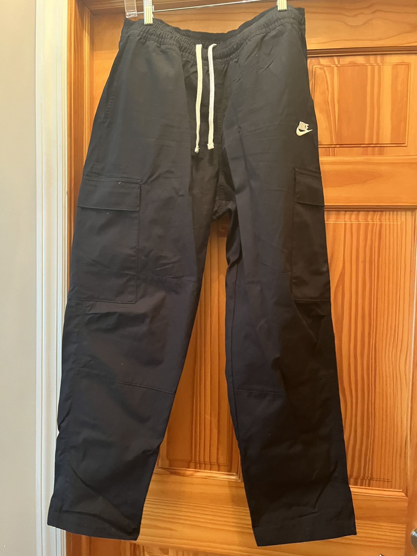 Nike men’s cargo pants. Color black. Size medium. Length from top to bottom is 40 inches. Lots of pockets