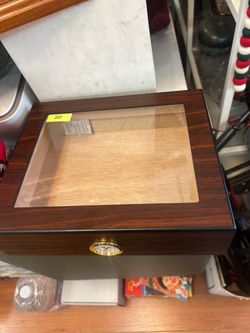 Wooden cigar humidor featuring a glass top and a front-mounted analog hygrometer