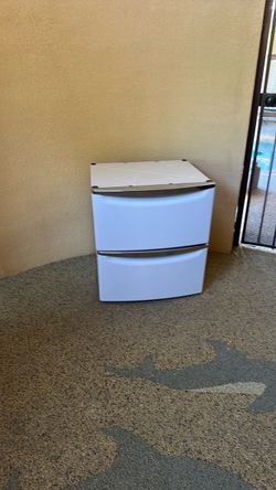 Front loading washer dryer stands with pull out drawer.