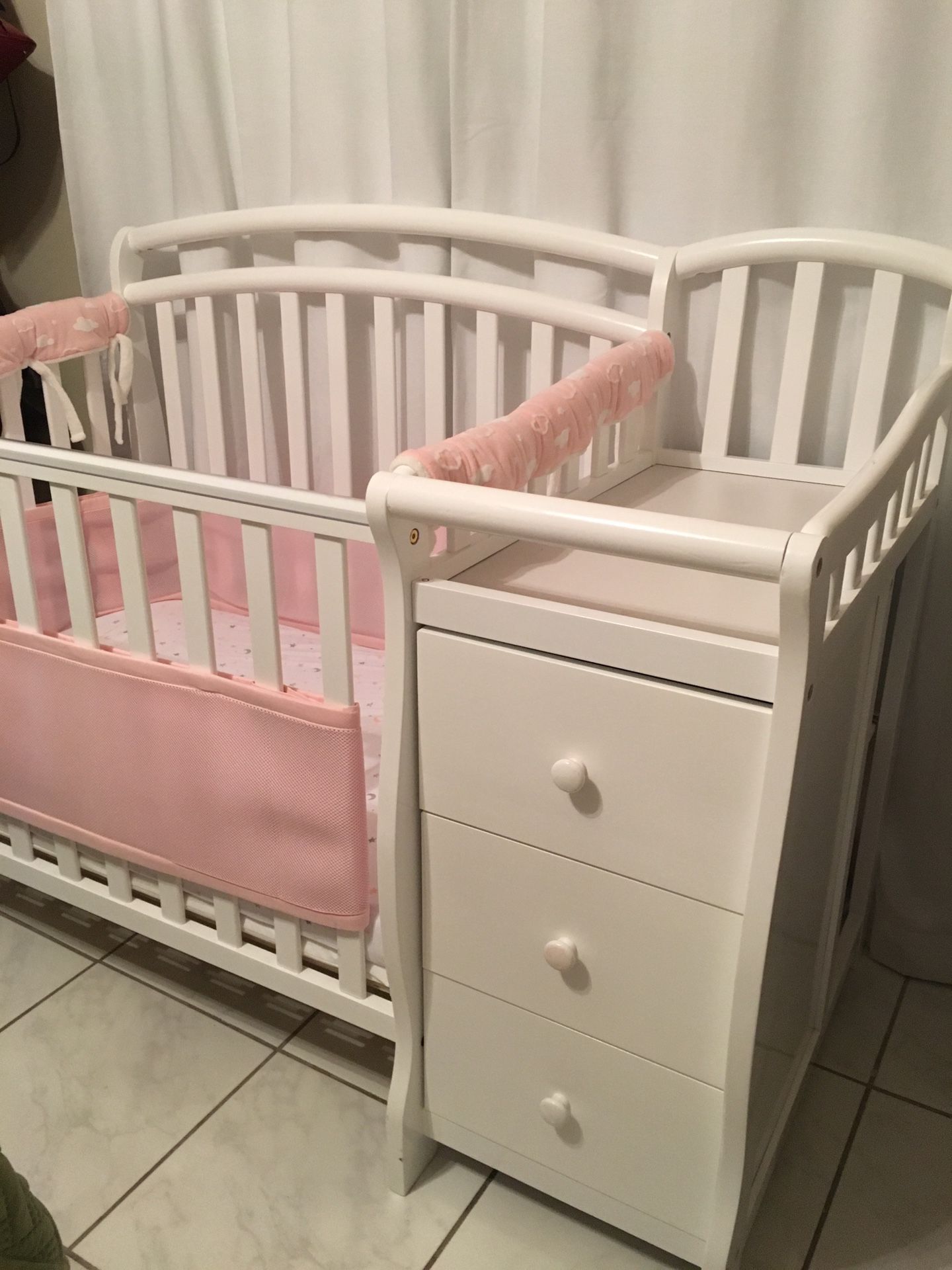 Mini crib with an attached changing table.