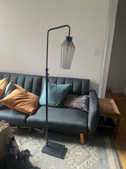 Black metal floor lamp with glass shade