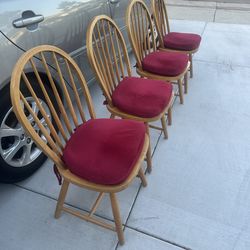 Four oak chairs with red seat cushions